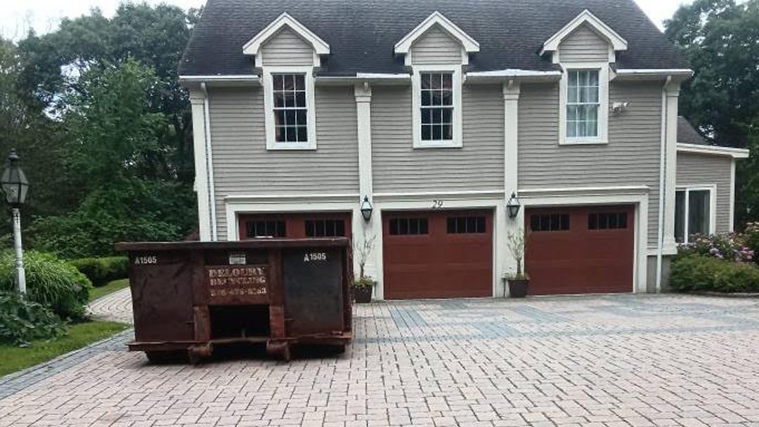 10-yard construction dumpster from Deloury Dumpster Rental delivered to a Boxford, MA driveway
